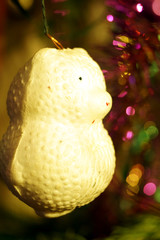 Bright and shiny decorations for Christmas and New Year hang on a green spruce.