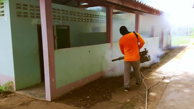 A man use fumigation mosquitoes machine for kill mosquito carrier of Zika virus and dengue fever prevention outbreak in school at the rainy season.Soft and blur focus.