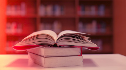 Stack of books in the library and blur bookshelf background