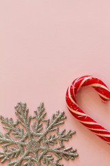 Christmas candy cane and snowflake on a pink background . space for text. the concept of new year and Christmas. the view from the top. postcard. banner. candy.