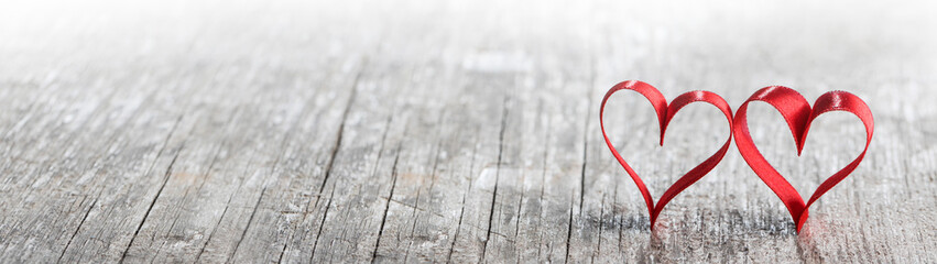 Red ribbon hearts on wood