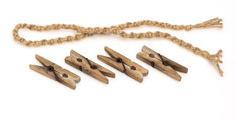 Wooden clothespins clamps next to a rope on a white background