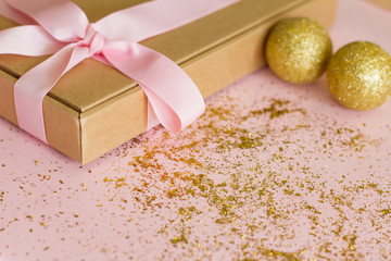 gift box with pink bow on pink background with sequins. Christmas Golden toys. Gift for birthday, Valentine's Day, Christmas, New year, mother's Day, women's day. space for text. postcard.