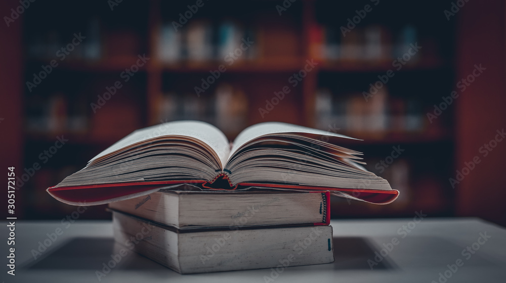 Poster stack of books in the library and blur bookshelf background