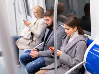 Girl with phone in metro car