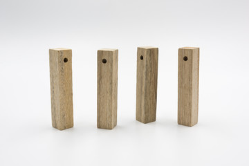 4 rectangular perforated wooden blocks neatly standing upright isolated on white background