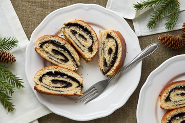 Slices of roll with poppy seeds on a white plate