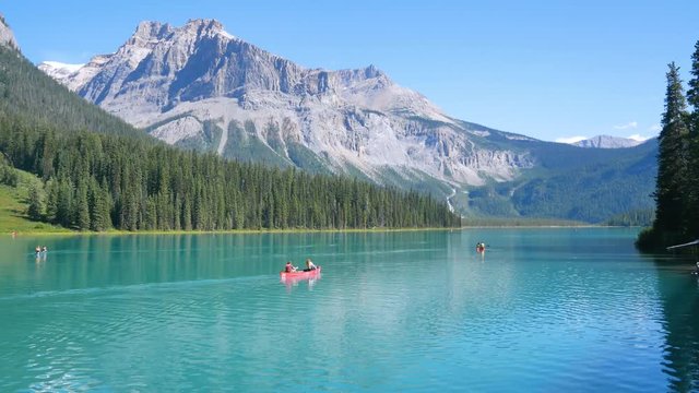 summer clear blue lake view (Emerald Lake with people canoeing in lake and beautiful mountain range) with clear blue sky in summer holiday in yoho/banff national park,Alberta,Canada