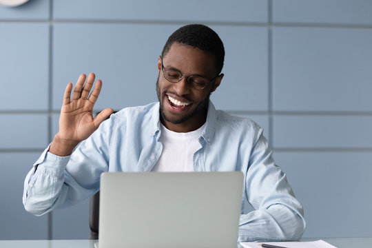 Smiling african American employee have video call on laptop