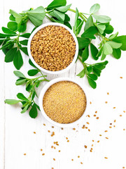 Fenugreek in two bowls with leaves on board top