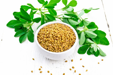 Fenugreek with green leaves in bowl on board