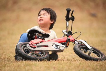 自転車に乗る練習中に転んだ男の子