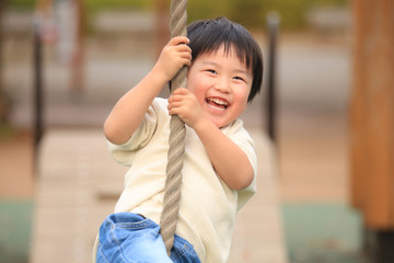 ターザンロープで遊ぶ男の子