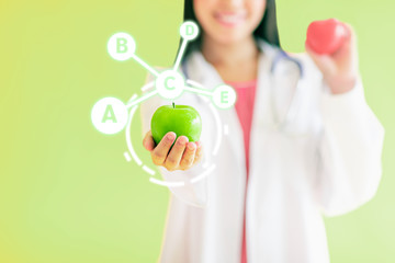 Doctor hold apple with vitamin icons..