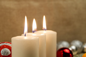 three burning candles with Christmas decoration. xmas composition.