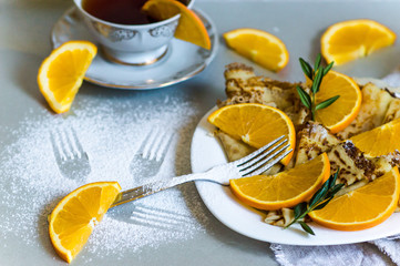 Thin pancakes and complex envelope with orange as a brunch for tea selective focus.Traditional Shrovetide dishes