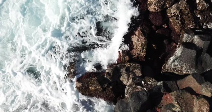 Drone close up of water hitting rocks