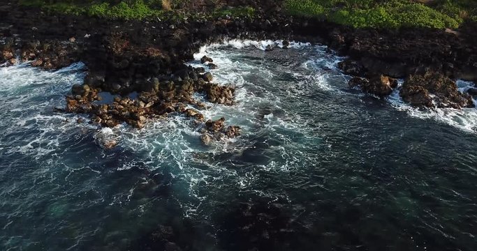 Pan left with drone of rocks and waves in Kauai, Hawaii