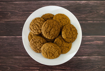 oatmeal cookies in a plate on a wooden table. View from above.