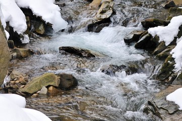 Stream in a snowy mountain forest