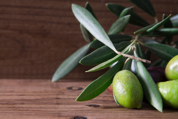 natural olives with leaves on wooden background