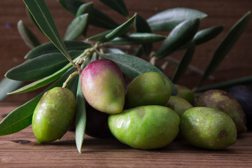 natural olives with leaves on wooden background