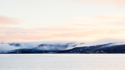 Obraz na płótnie Canvas A winter view of the rocky coastline close to the Norwegian town of Kirkenes.