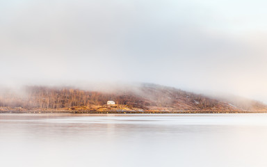 Kirkenes Coastline.  A home shrouded in mist viewed from the Kirkenes coastline.  Kirkenes is a town located in Northern Europe close to the Russian border.