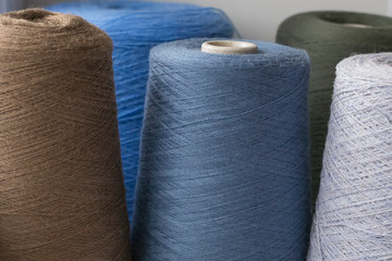 Dark Multi-colored bobbins of wool yarn for hand and machine knitting