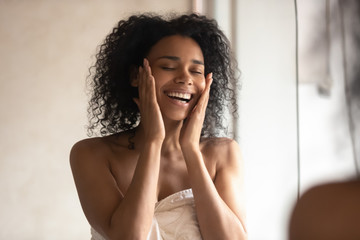 Happy african American woman touch healthy skin in bath