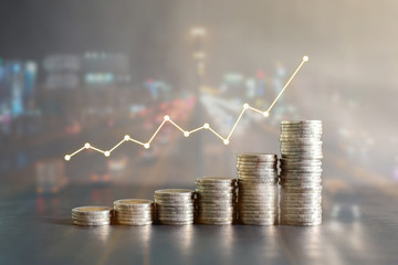 Double exposure stack of Thailand coins on black wooden table with profit graph, growth up, success on blur background of night road. Business, finance, marketing, e-commerce concept and design