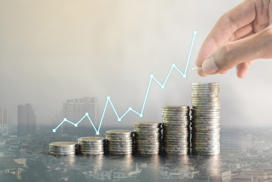 Double exposure hand stacking coins on blur background of city with profit line chart growth up. Business, finance, marketing, e-commerce concept and design