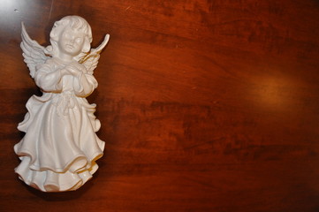 Angel white statue isolated on brown surface