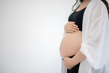 Beautiful young women in the third trimester of pregnancy Pregnant woman holding arms in her stomach Expecting child concepts White background