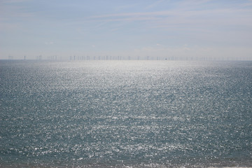 Sparkling sea with wind turbines on the horizon