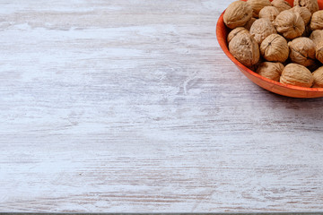 Wood plate with nuts on white wood.