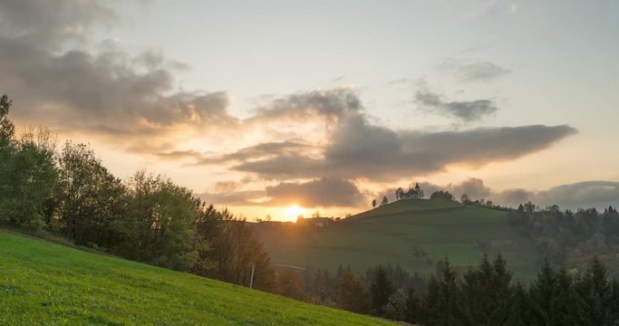 4K Timelapse view of the hills, colorful forest and the Sv Sobota church. Slovenia sunset in autumn