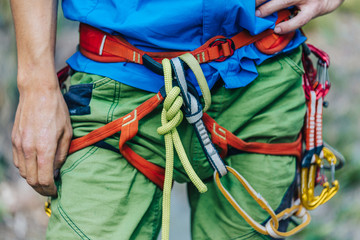 Close up detail of a man wearing climbing harness. Outdoor climbing equipment.