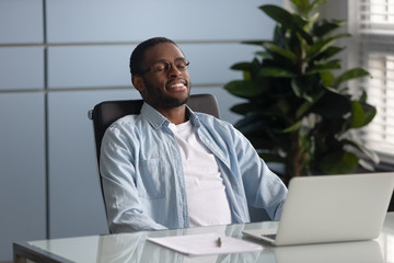 Calm african American employee relax in chair at work