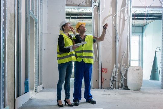 Construction Worker And Architect Discussing Work To Be Done At Site