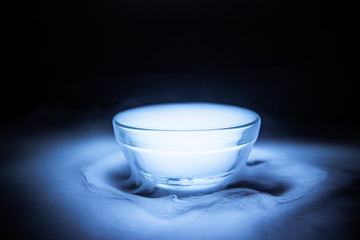 The smoke from dry ice in a glass bowl black background.