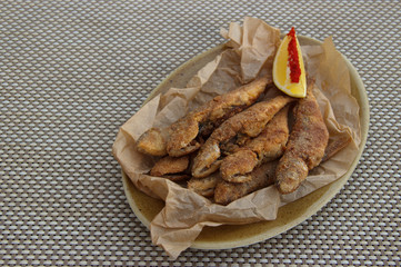 fried surmullet on table. fish fried in corn flour, served with lemon