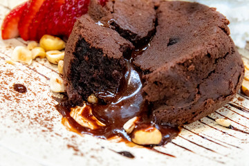 Chocolate lava cake with ice cream on white plate.
