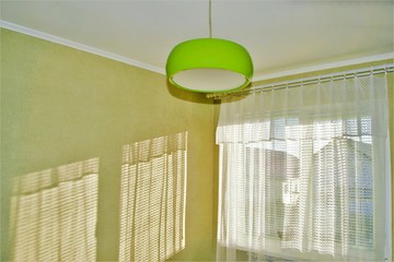 the corner of the room with a window and green chandelier,interior