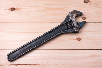 Obraz premium Well used adjustable wrench on a wooden surface. Work concept