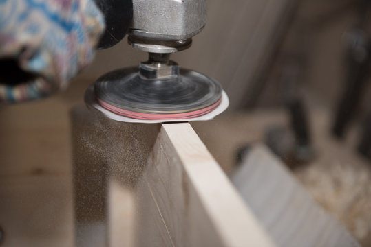 Grind A Wooden Product. Sanding Machine. A Man Is Grinding A Stool.