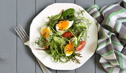 Cucumber, tomato, egg, fresh green salad with black sesame, top view, copy space