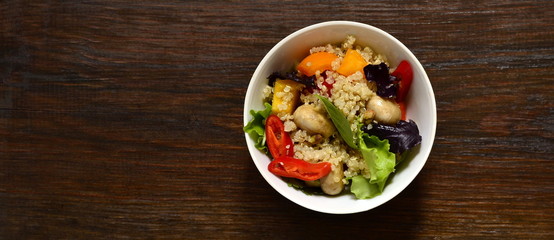 Salad with quinoa, sweet pepper, mushrooms, herbs and pistachios. Healthy nutrition. Vegetarian concept, top view, copy space