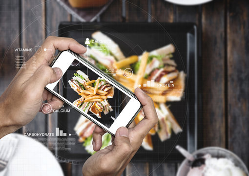 Food Nutrition Scanning Technology, and Healthy eating Lifestyles. a man using mobile smart phone checking nutrition facts of club sandwich and french fries 