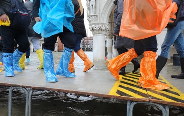 people with plastic leggings on the footbridge in Venice in Ital